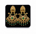 Ornate gold chandelier earrings with green gems